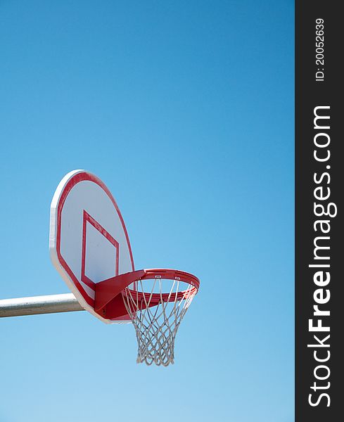 Basketball hoop against bright blue sky