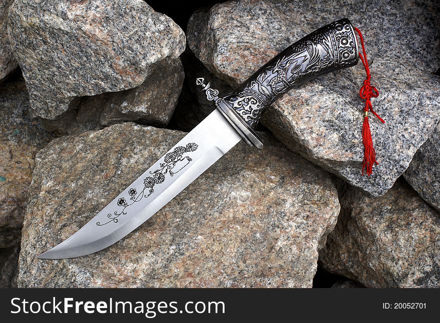 The big hunting knife on granite stones. The big hunting knife on granite stones.