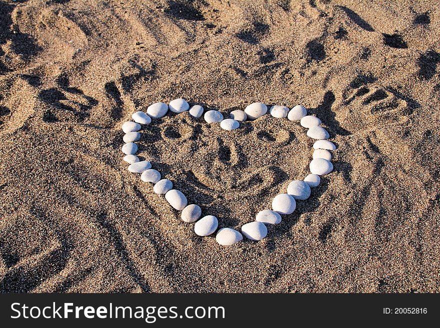 Funny heart on the beach sand