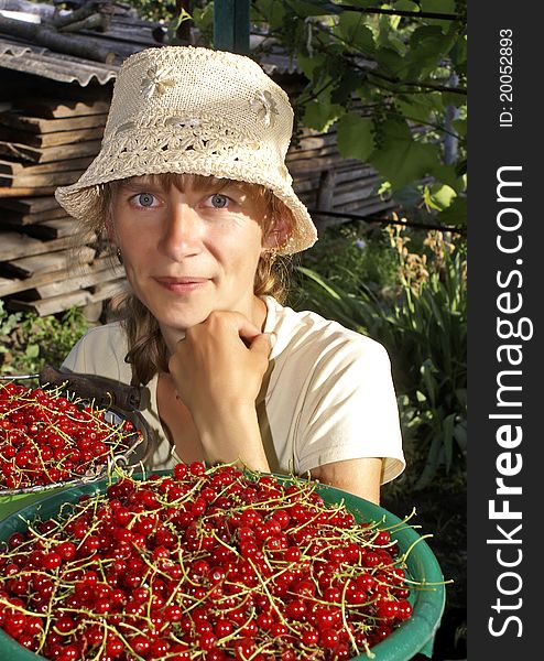 The young woman sells a red currant in the marcet. The young woman sells a red currant in the marcet.