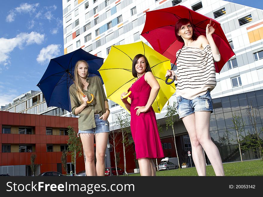 Pretty young girls with umbrellas on a sunny day