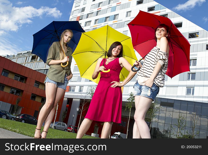 Pretty young girls with umbrellas on a sunny day