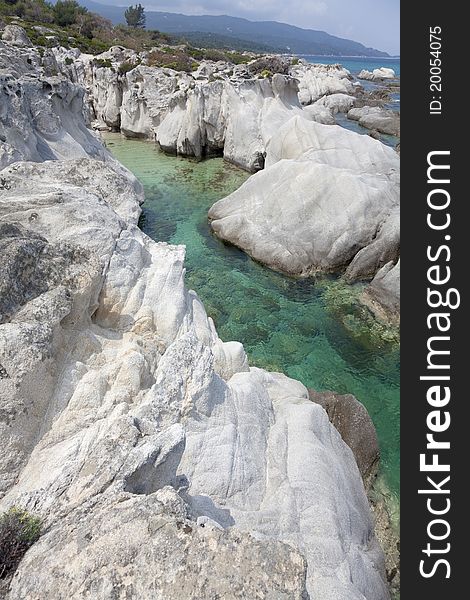 Beautiful rocky beach in the area of Halkidiki in Greece. Famous beach with turquoise water with the name ''Kavourotripes''