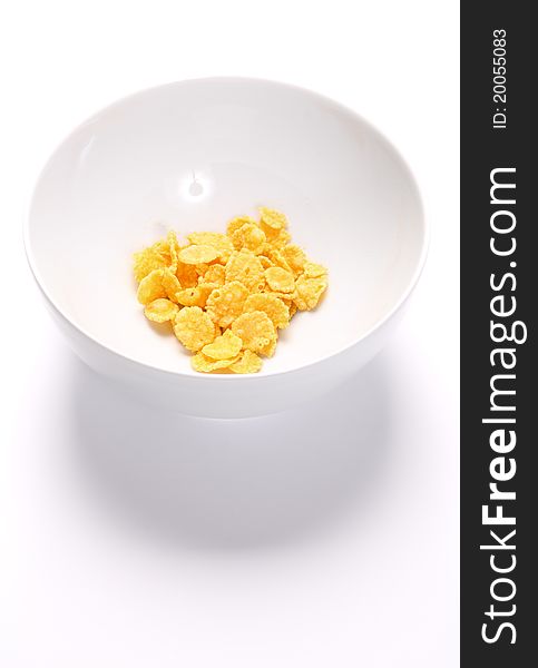 Bowl with a little of cornflakes over white background