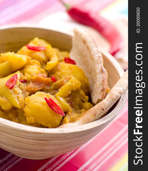 Bowl of spicy curry with potato and chilly Selective focus; shallow depth of field.