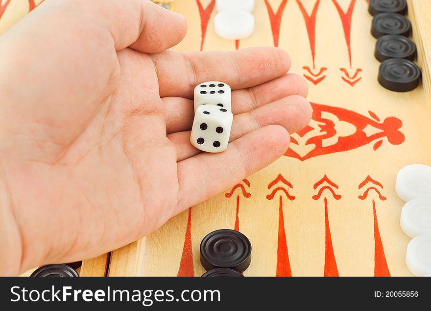 Hand with dices and backgammon