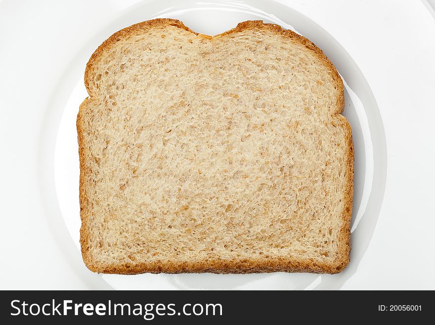 A slice of whole wheat bread on a white plate