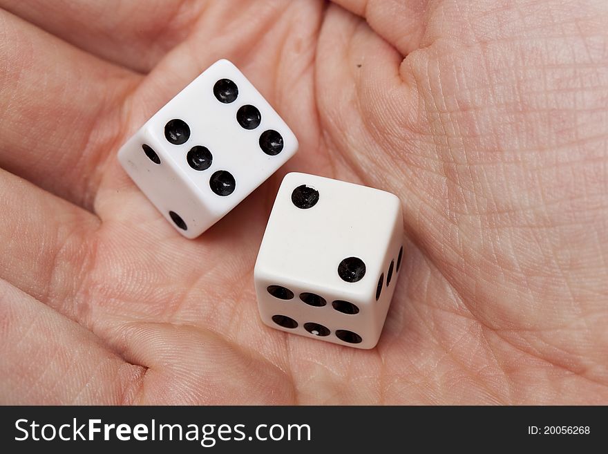 White dice with black dots in a persons hand