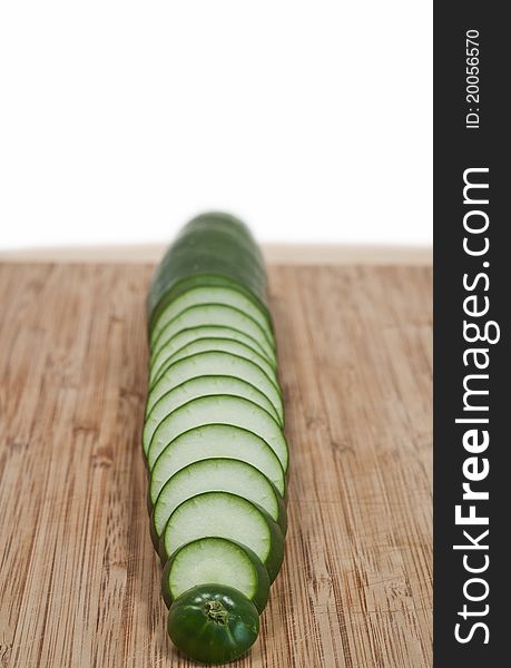 Sliced cucumber vertical on cutting board isolated white background