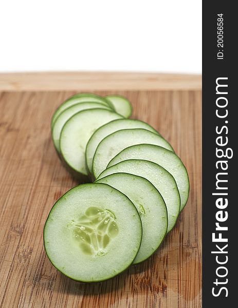 Sliced cucumber in wavy formation vertical isolated white background. Sliced cucumber in wavy formation vertical isolated white background