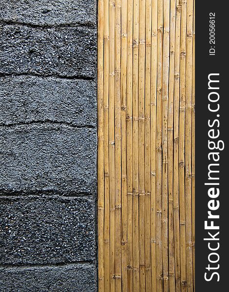 Vertical line of bamboo and horizontal grooved line on rustic concrete wall. Vertical line of bamboo and horizontal grooved line on rustic concrete wall