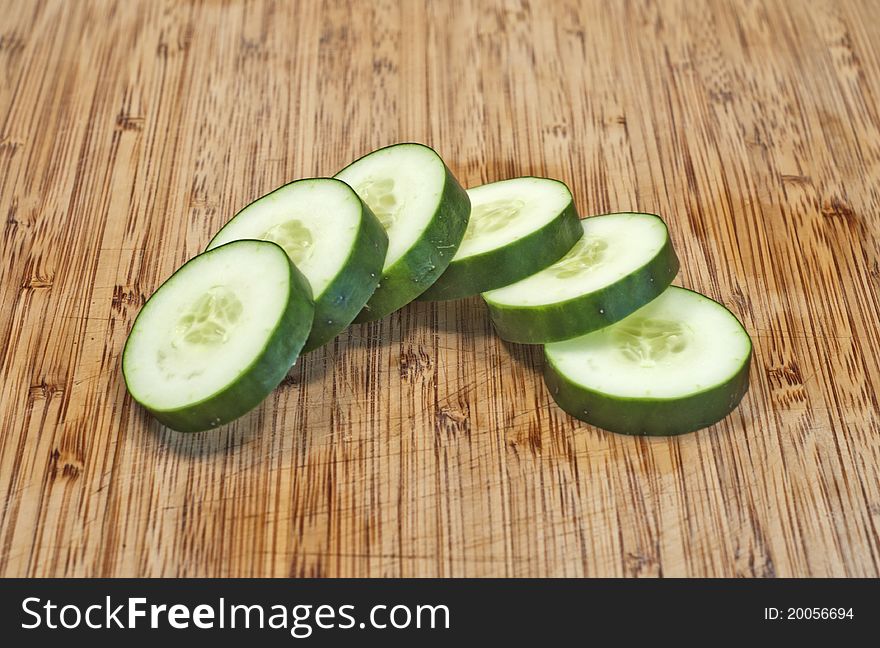 Sliced cucumber in half circle on cutting board close up