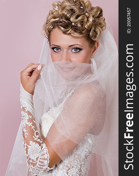 Portrait of the beautiful bride in studio on a pink background. Portrait of the beautiful bride in studio on a pink background