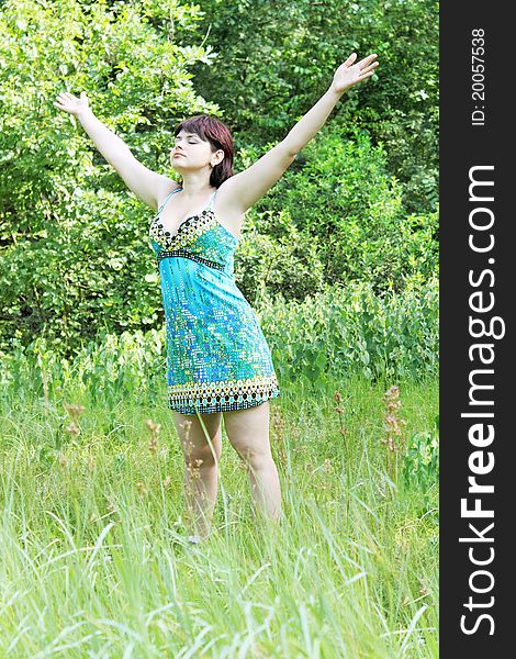 Young woman raised hands upward on nature