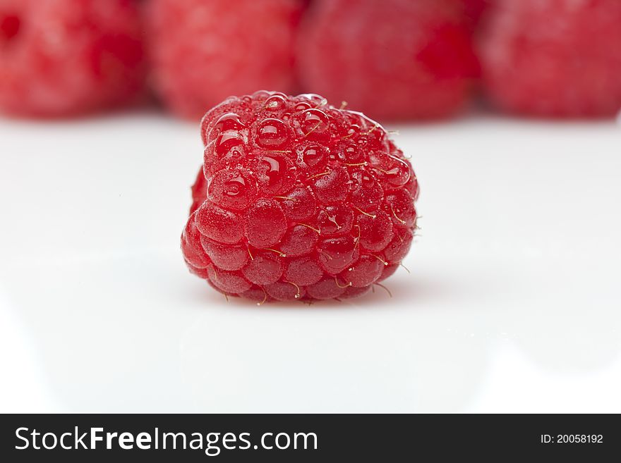 Fresh red raspberries against a white background