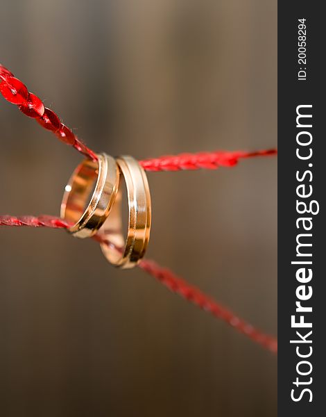 Wedding rings on on a red tape