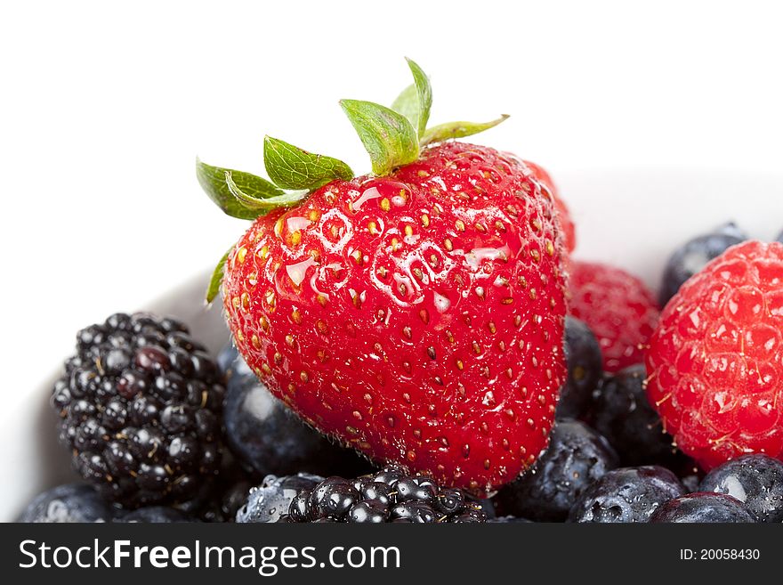A group of berries in a bowl against a white background. A group of berries in a bowl against a white background
