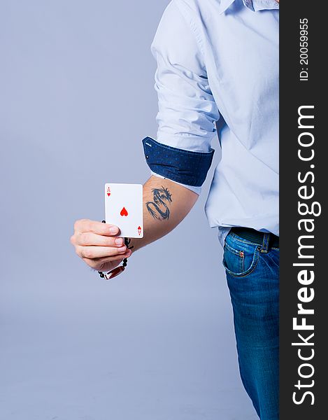 Poker player with an Ace of heart in his hand and a black dragon tatoo