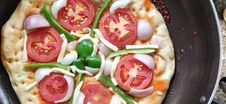 Top View Of Indian Home Made Pizza Cream And Dark Golden Brown Color Decorated With Tomato, Capsicum, Cheese Being Cooked. Royalty Free Stock Images
