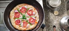 Top View Of Indian Home Made Pizza Cream And Dark Golden Brown Color Decorated With Tomato, Capsicum, Cheese Being Cooked. Stock Images