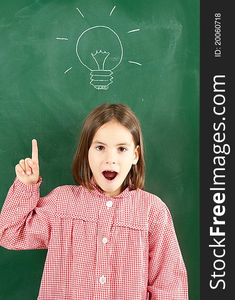 Little girl with blackboard and lightbulb over her head