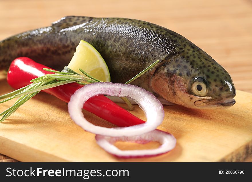 Fresh trout and other ingredients on cutting board