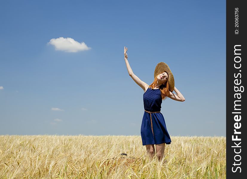 Redhead girl at spring wheat field. Outdoor,