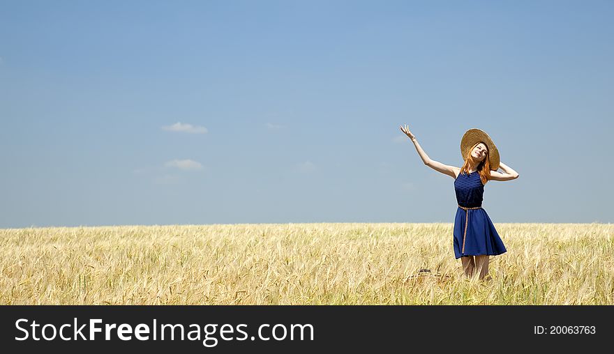 Redhead girl at spring wheat field.