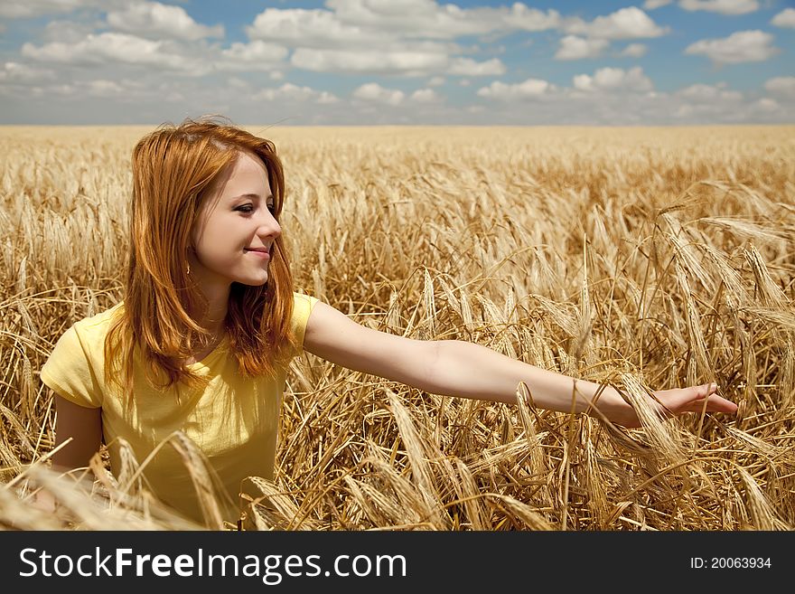 Girl at wheat field at summertime. Outdoor photo.