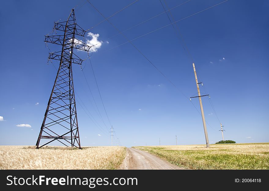 Electrical net of poles on a panorama of blue sky and wheat field. Electrical net of poles on a panorama of blue sky and wheat field