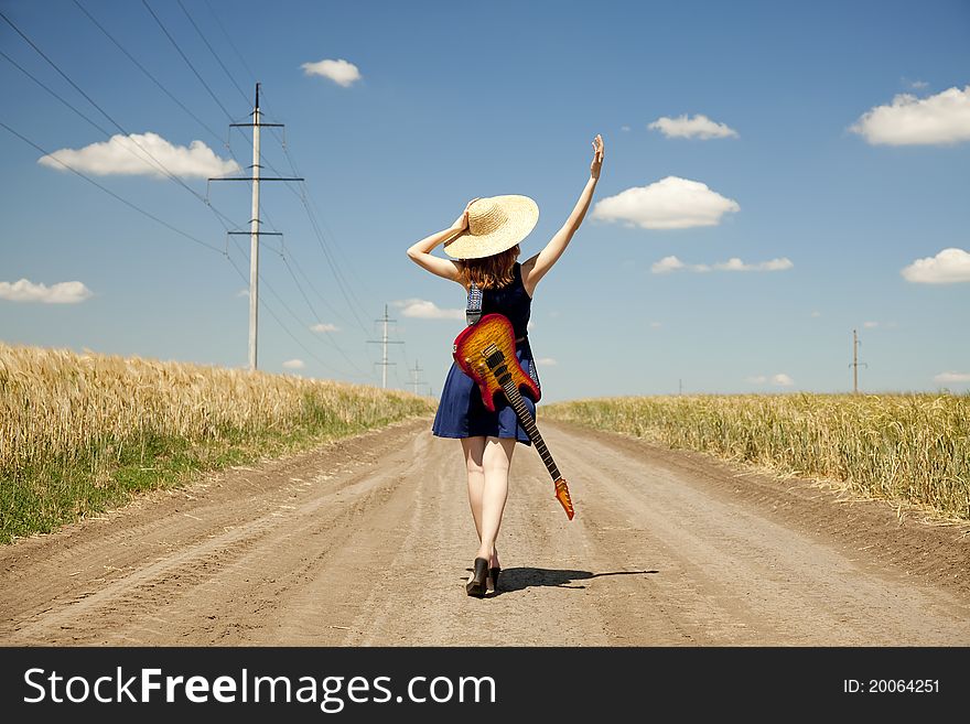 Rock girl with guitar at countryside.