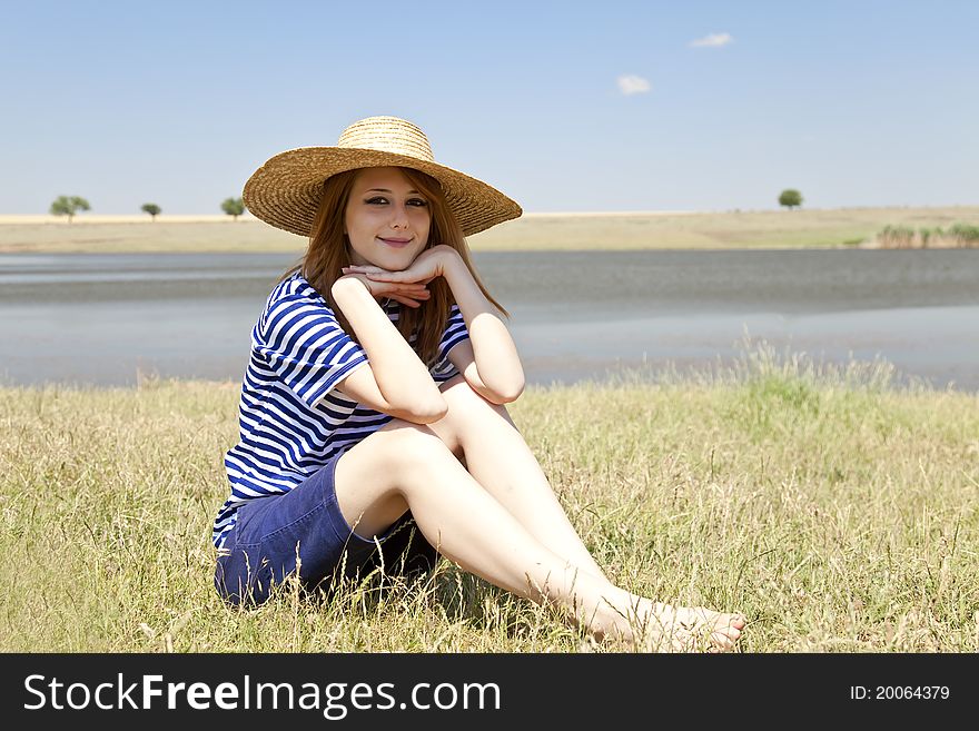 Beautiful redhead girl at countryside nead lake.