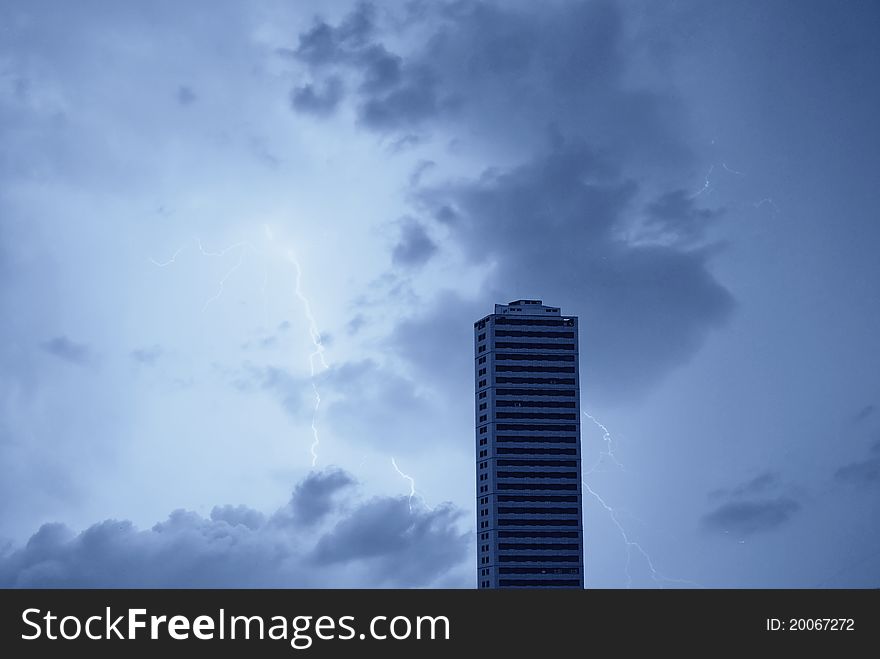 Skyscraper at night under stormy sky