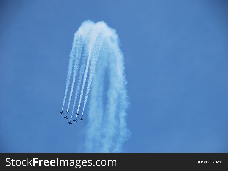 At a flight show a formation of aircraft make a looping. At a flight show a formation of aircraft make a looping