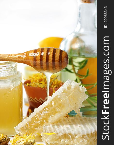 Jar of honey and honeycomb on white