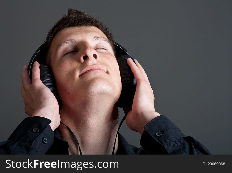 Young male person listening to music with headphones