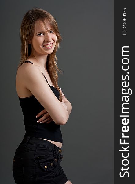 Happy fitness woman standing smiling against gray background
