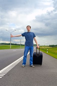 The Young Man Pending On Road With Suitcase Stock Photography The Young Man Pending On Road With Suitcase Stock Photography