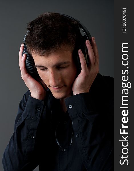 Young male person listening to music with headphones