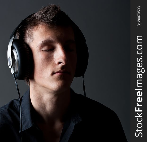 Young male person listening to music with headphones