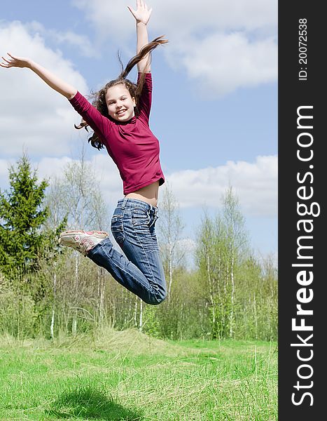 The jumping girl against the blue sky