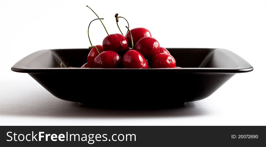 Red cherries in a black bowl. Red cherries in a black bowl