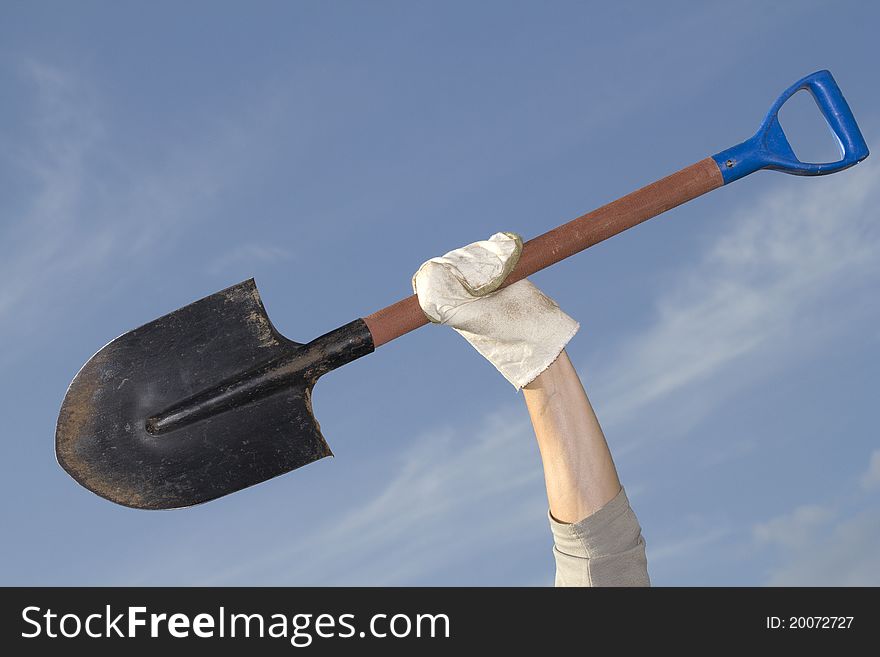 Tool shovel in hand, working against the sky. Tool shovel in hand, working against the sky