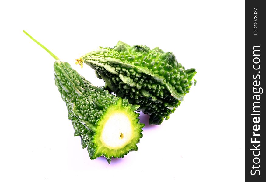 Bitter gourd in two halves over white background.