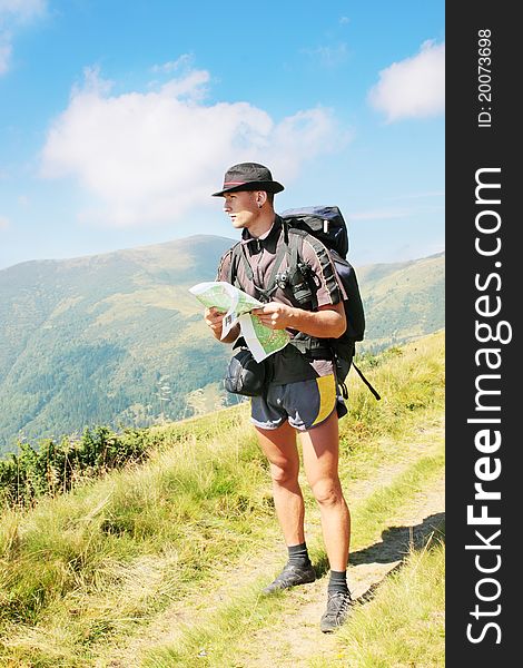 Man with the knapsack holds the map. Man with the knapsack holds the map