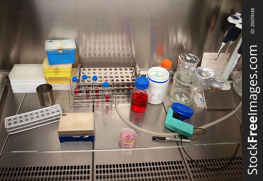 Chemicals, test tubes and pipettes in a laminar flow cabinet. Chemicals, test tubes and pipettes in a laminar flow cabinet.