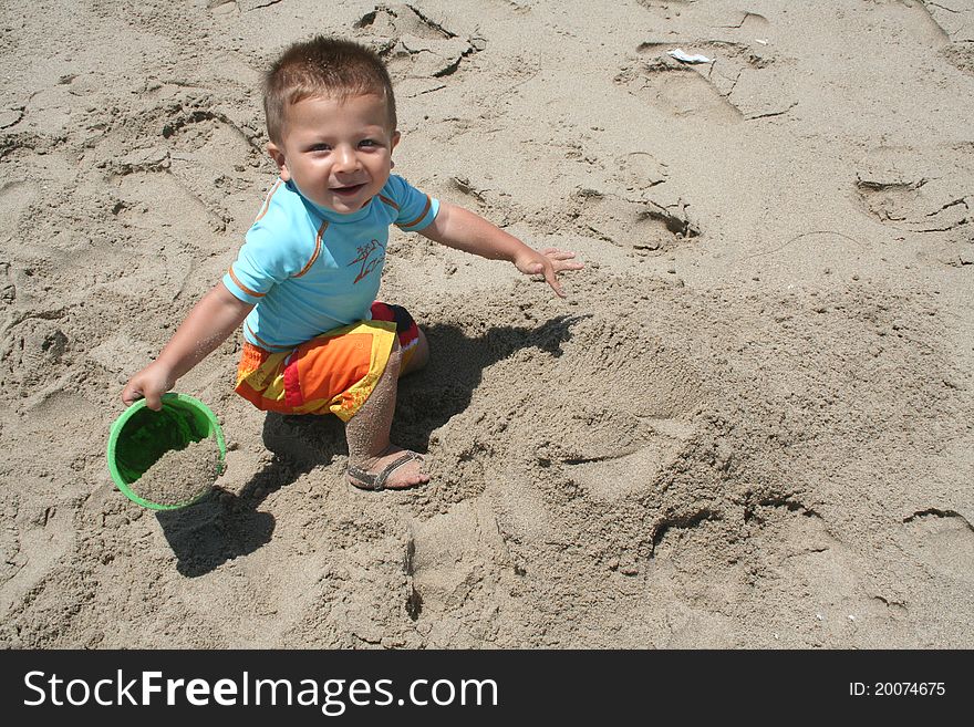 Boy holding a bucket of sand on the beach. Boy holding a bucket of sand on the beach.