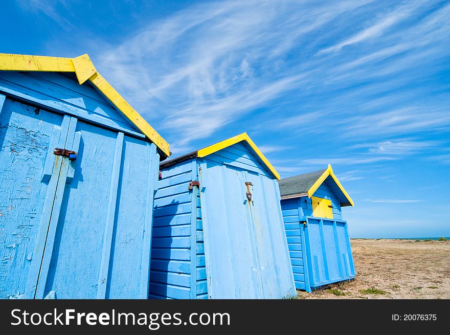 Blue beach huts against an empty beach in England. Blue beach huts against an empty beach in England.