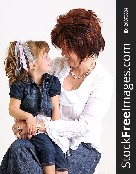 Young daughter and mother dressed in blue and white smiling. Young daughter and mother dressed in blue and white smiling