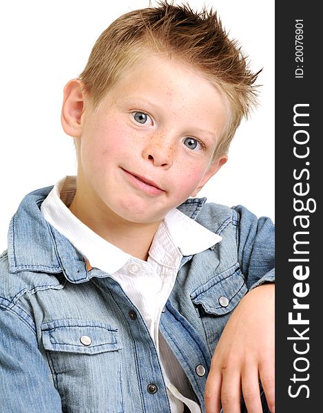 Young attractive boy wearing a blue jean jacket and looking goofy smiling